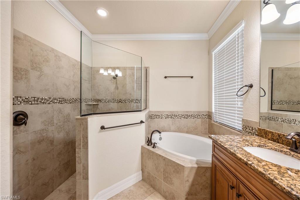 9234 Veneto Place Naples, FL 34113 - Photo 19 of 38 a bathroom with a granite countertop bathtub shower sink and mirror