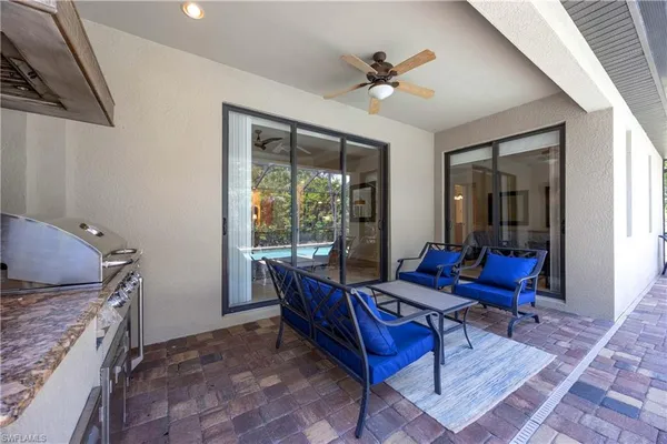 a living room with furniture a rug and a floor to ceiling window