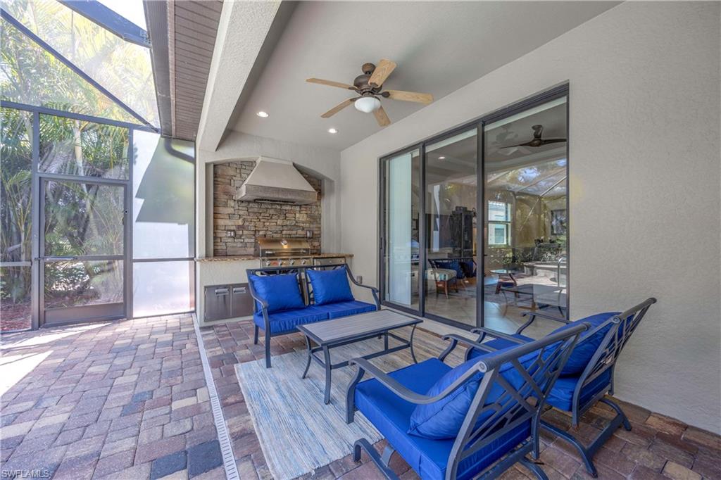 9234 Veneto Place Naples, FL 34113 - Photo 29 of 38 a living room with furniture a rug and a floor to ceiling window