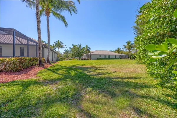 a front view of a house with a yard and palm trees