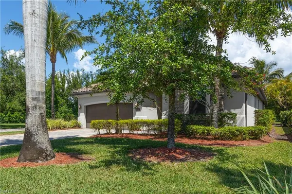 a front view of a house with fountain and garden