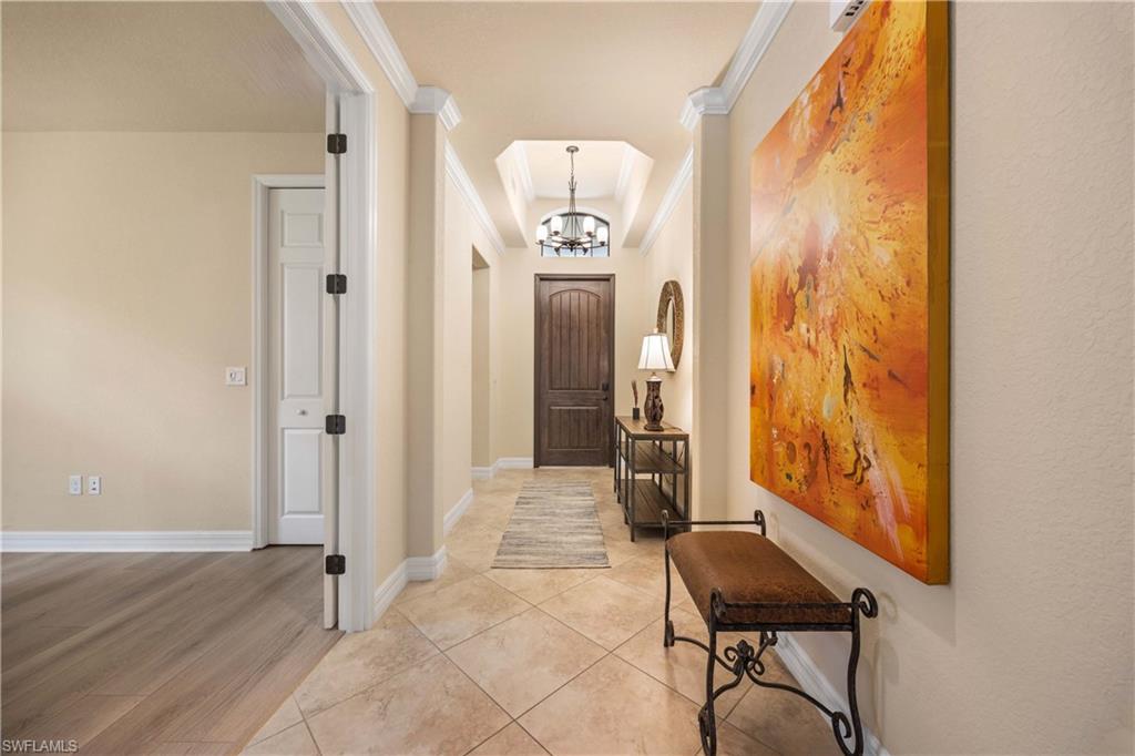 9234 Veneto Place Naples, FL 34113 - Photo 4 of 38 a view of a hallway with wooden floor and a livingroom with furniture