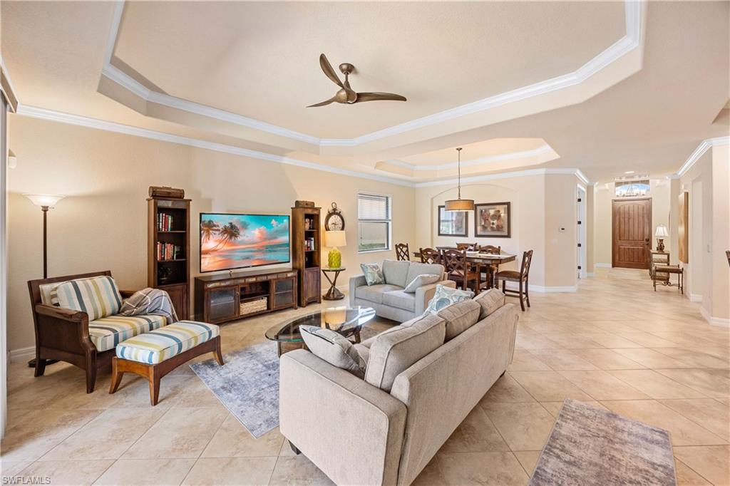 9234 Veneto Place Naples, FL 34113 - Photo 8 of 38 a living room with furniture and a flat screen tv