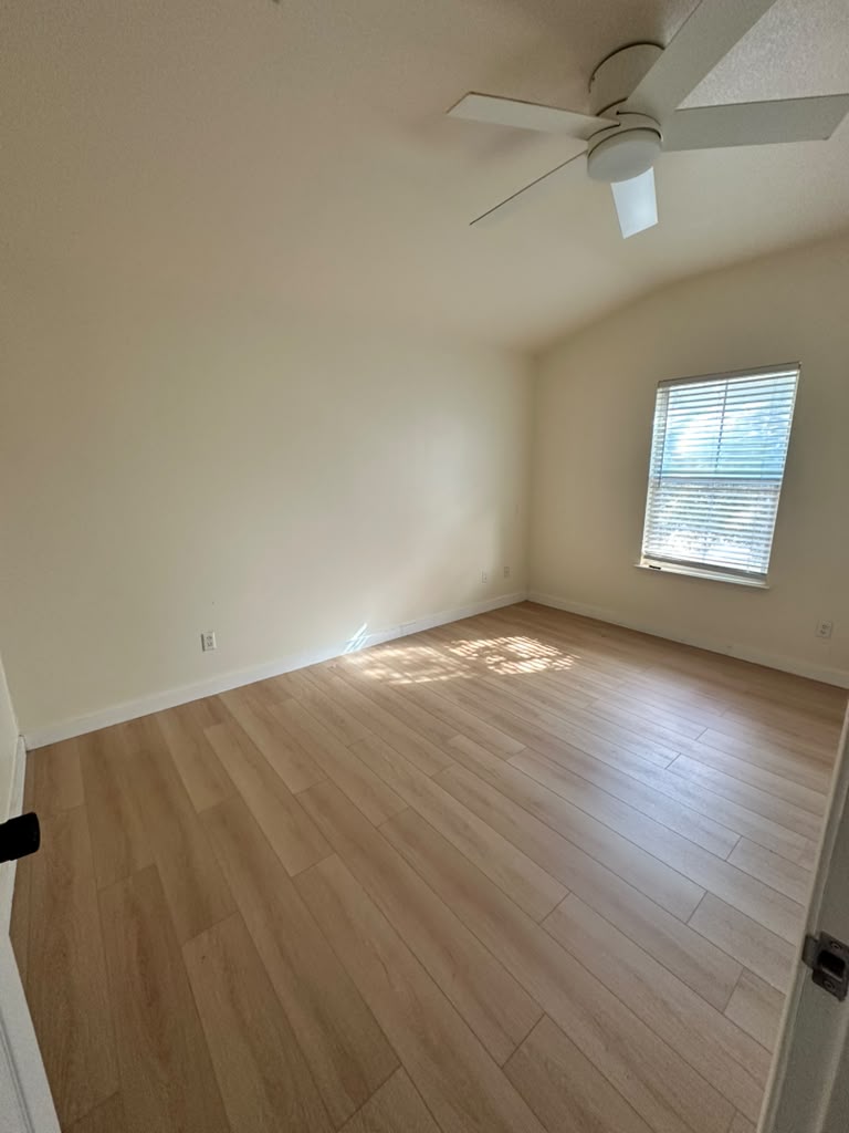 1981 Prairie Rock Way Round Rock, TX 78664 - Photo 10 of 22 Warm wood flooring and vaulted ceilings create a welcoming atmosphere in this spacious bedroom.