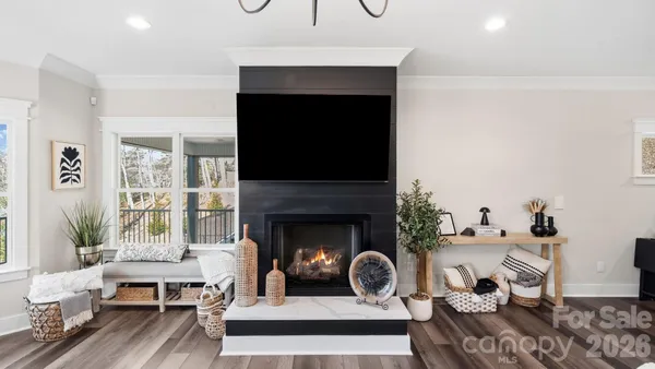 a kitchen with stainless steel appliances granite countertop a stove a sink dishwasher a refrigerator white cabinets and wooden floor next to a window