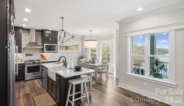 a kitchen with stainless steel appliances kitchen island granite countertop a dining table chairs and granite counter tops