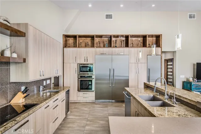a kitchen with stainless steel appliances granite countertop a sink and a refrigerator