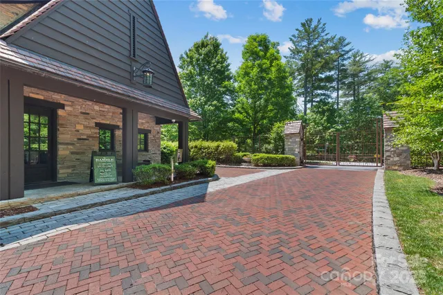 a view of a house with potted plants and a large tree