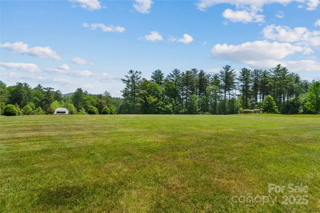 a view of a swimming pool with seating area and trees in the background