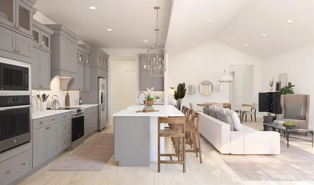 a living room with furniture a flat screen tv and kitchen view