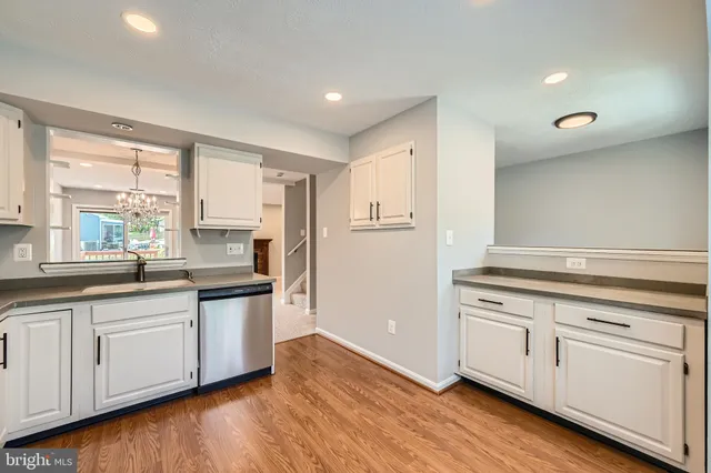 a kitchen with white cabinets and sink