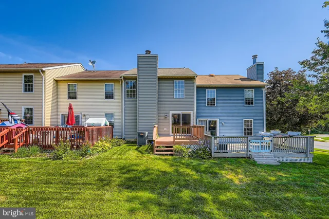 a front view of a house with a yard and chairs