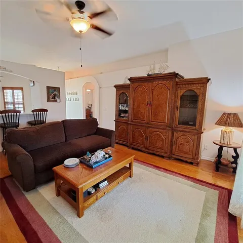 a living room with couches dresser and a window