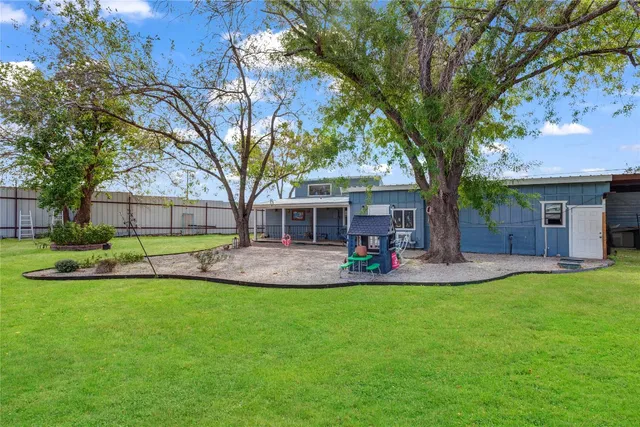 a view of a house with a yard and sitting area