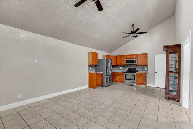 a kitchen with stainless steel appliances granite countertop a refrigerator and a stove top oven