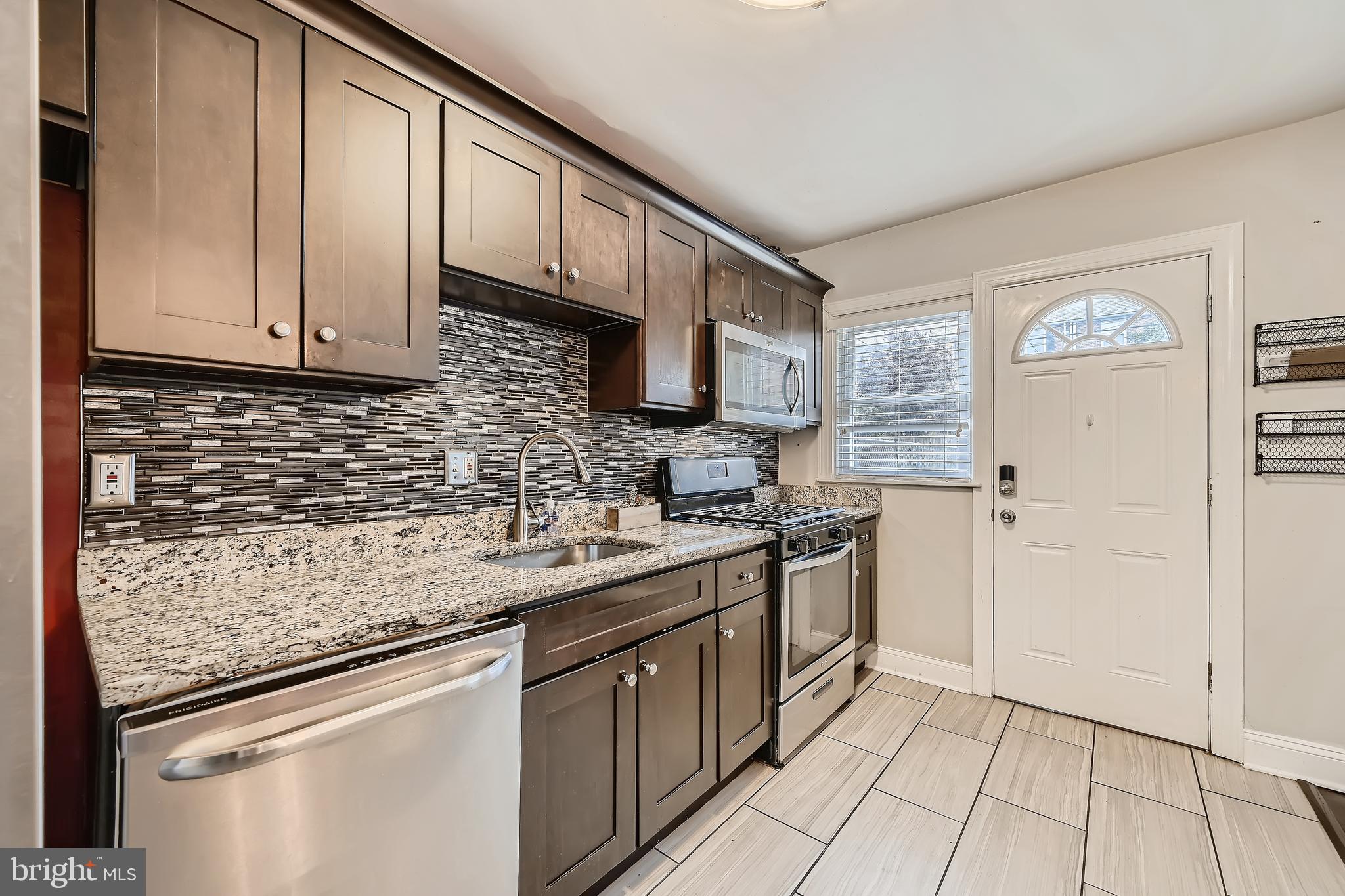 3828 Ednor Road Baltimore, MD 21218 - Photo 13 of 27 a kitchen with stainless steel appliances granite countertop a sink stove and refrigerator