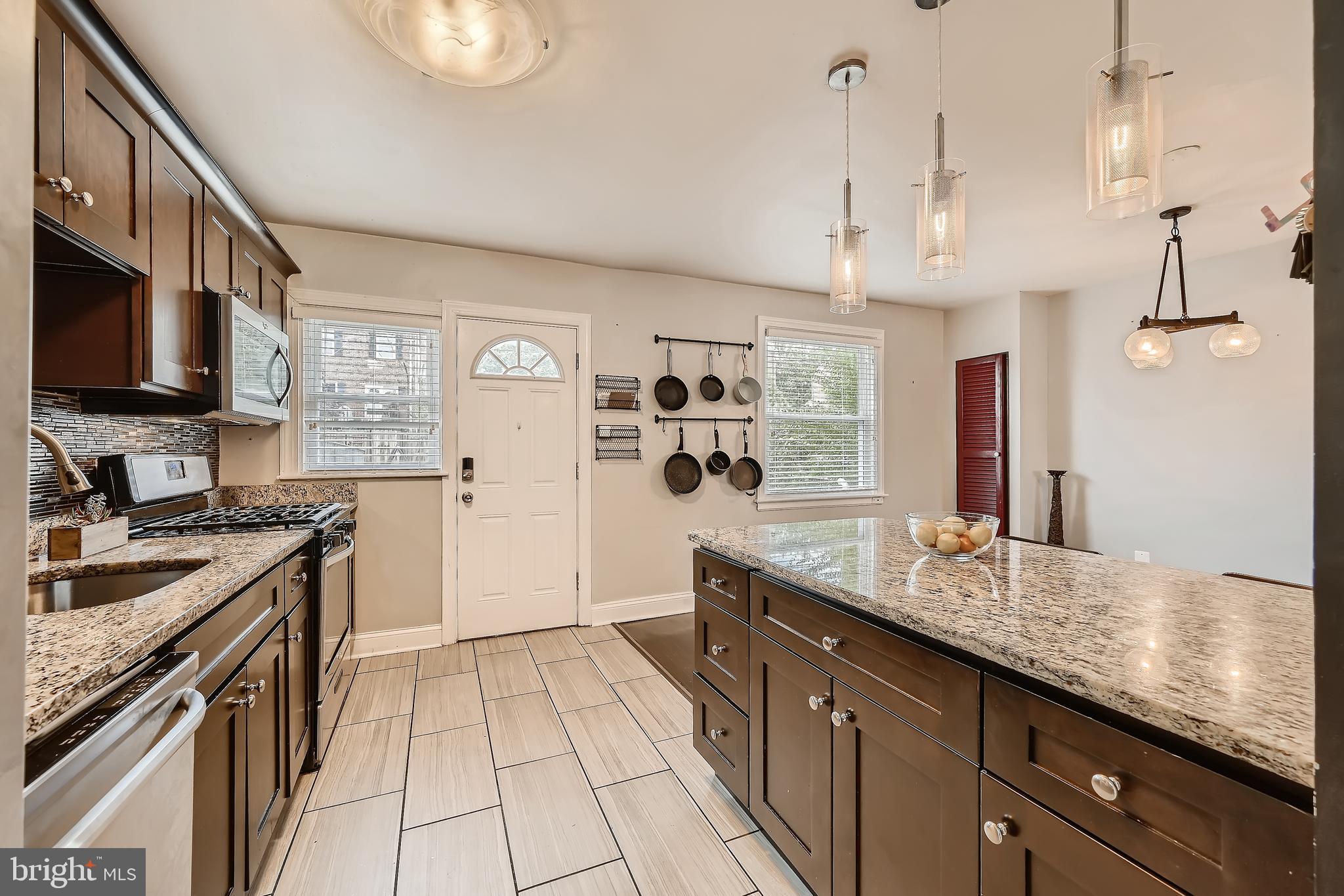 3828 Ednor Road Baltimore, MD 21218 - Photo 14 of 27 a kitchen with stainless steel appliances granite countertop a sink stove and refrigerator