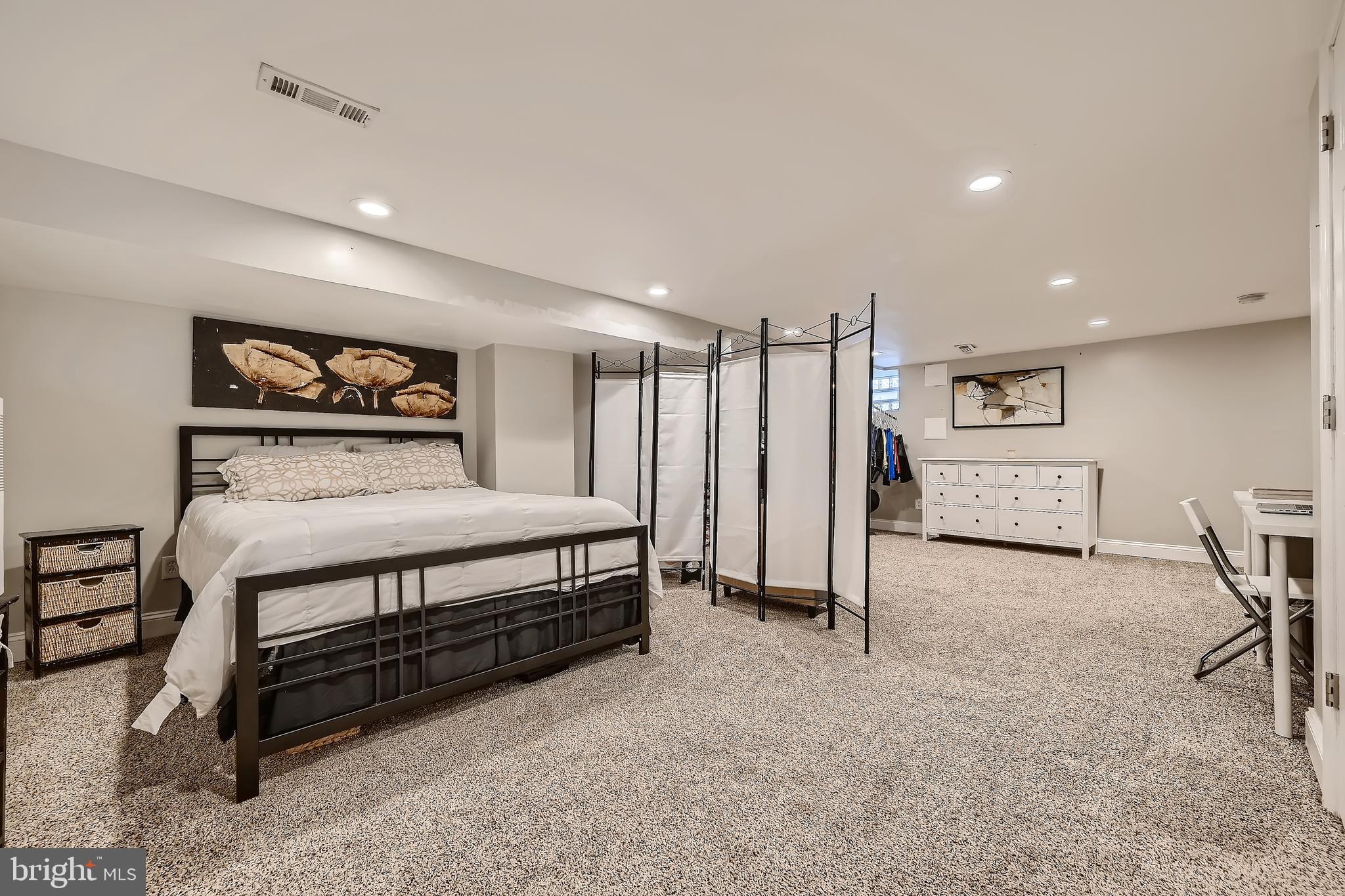 3828 Ednor Road Baltimore, MD 21218 - Photo 23 of 27 a spacious bedroom with a bed a desk and chair