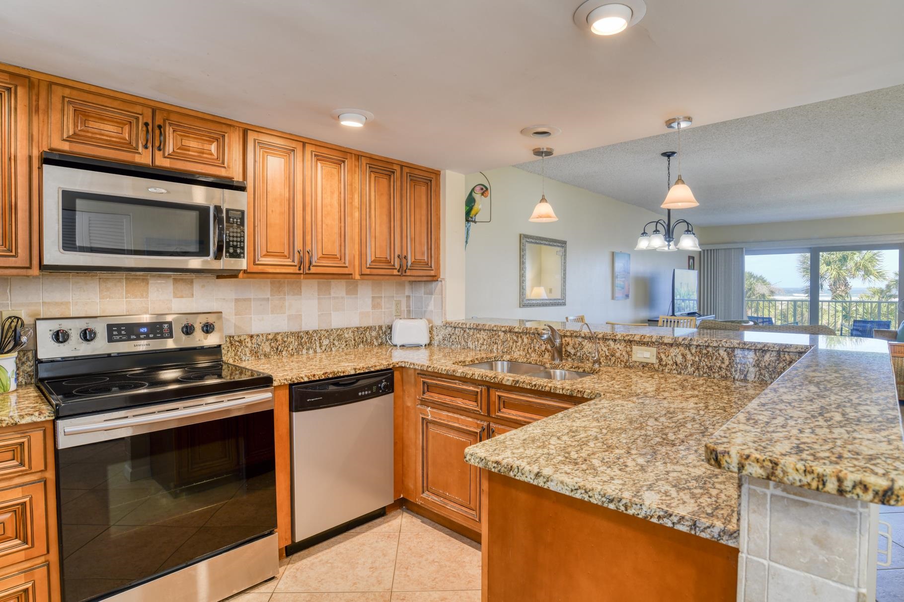 4 Ocean Trace Road, Unit 323 St. Augustine Beach, FL 32080 - Photo 3 of 37 a kitchen with stainless steel appliances granite countertop a stove microwave and sink