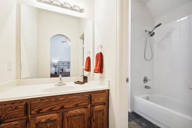 a bathroom with a tub sink and mirror