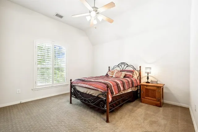 a spacious bedroom with a bed and a ceiling fan