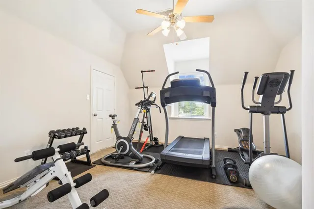a room with gym equipment and wooden floor