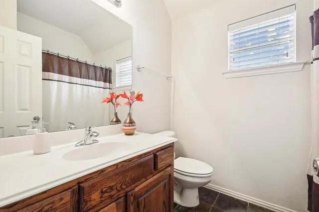 a bathroom with a sink vanity mirror and toilet