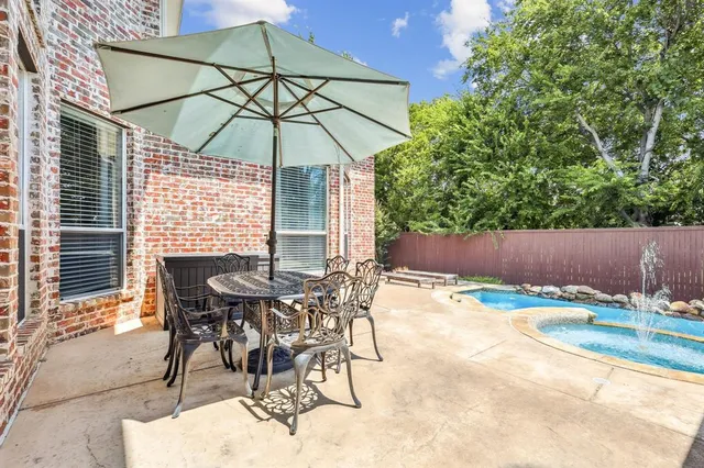 a patio with a table and chairs under an umbrella