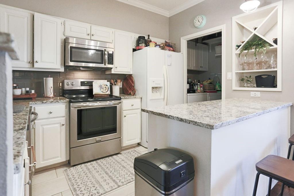 1307 Kinney Avenue, Unit 121 Austin, TX 78704 - Photo 4 of 12 a kitchen with stainless steel appliances granite countertop a stove a sink and a microwave