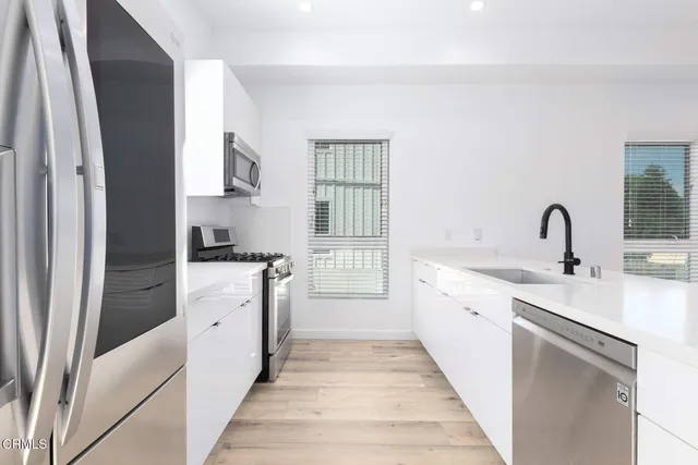 a kitchen with white cabinets and sink