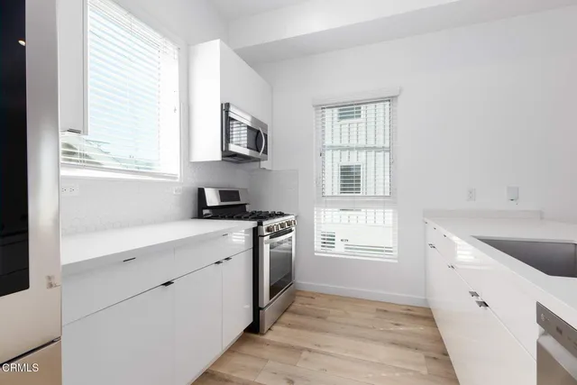 a kitchen with granite countertop white cabinets and white appliances