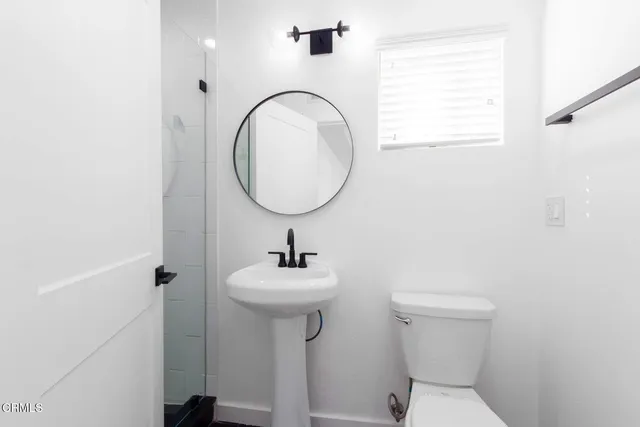 a bathroom with a toilet sink and mirror