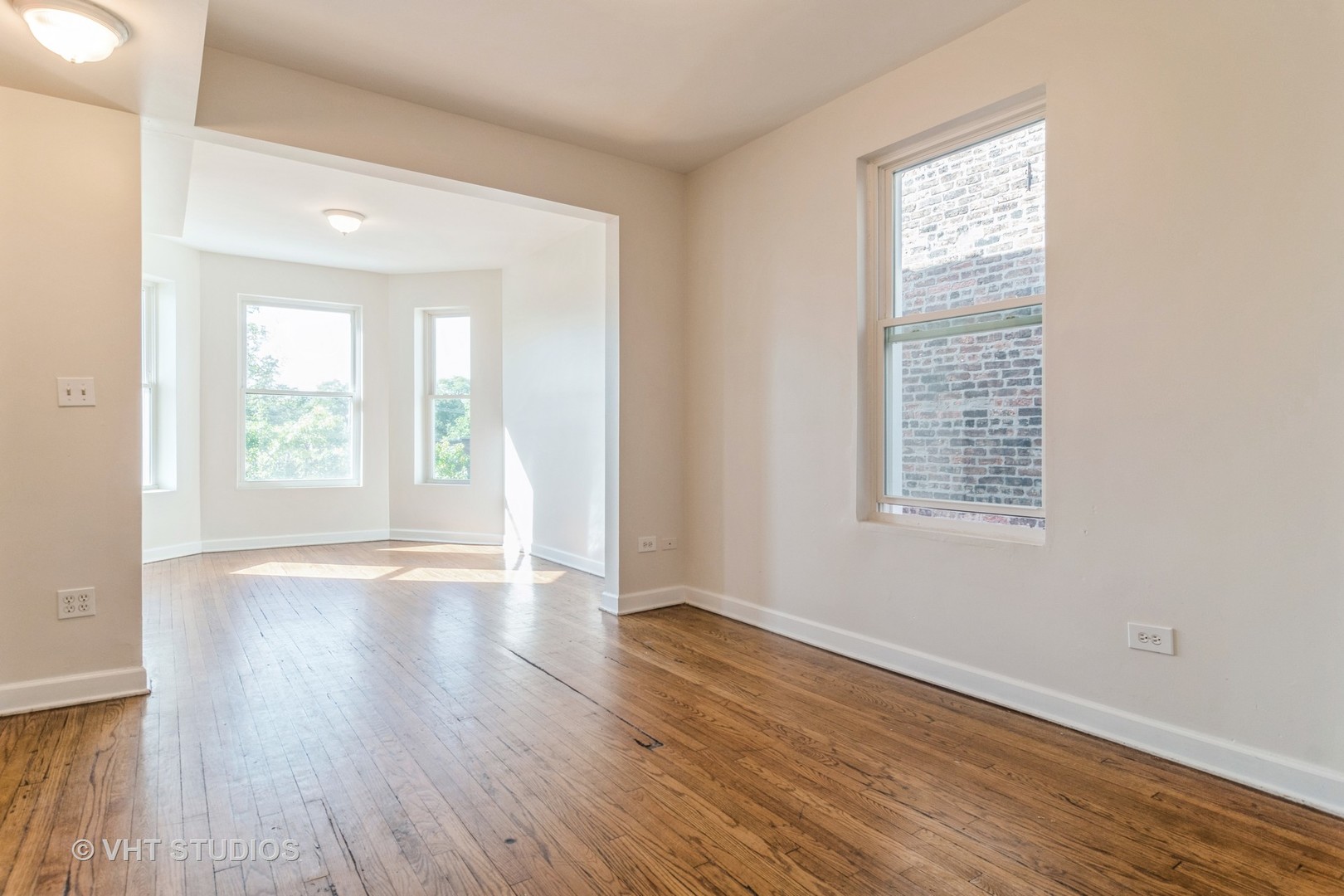 3406 West Walnut Street, Unit 1W Chicago, IL 60624 - Photo 4 of 11 an empty room with wooden floor and windows