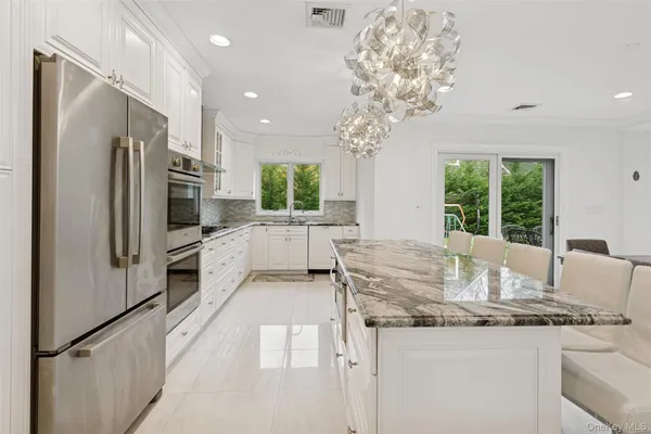 a kitchen with stainless steel appliances granite countertop a refrigerator and a sink