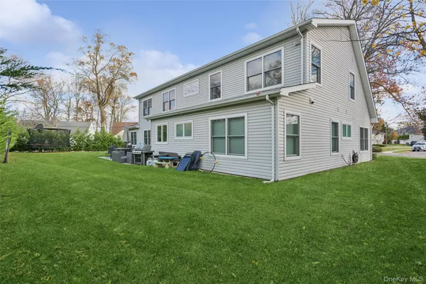 a view of a yard in front of a house with large trees