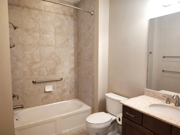a view of a livingroom with wooden floor and a bathroom