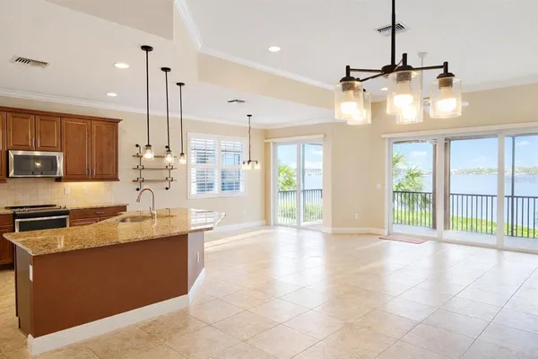 a large kitchen with granite countertop a large counter top a stove a sink and cabinets