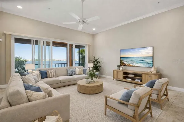 a living room with furniture a chandelier a window and a flat screen tv