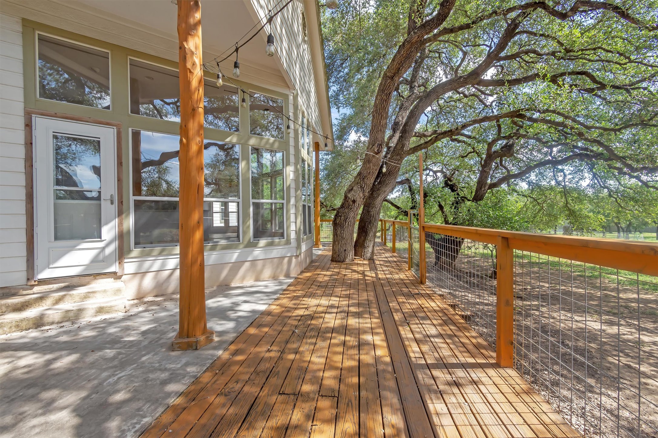 1120 Meadow Ridge Drive Austin, TX 78737 - Photo 30 of 40 Discover a charming outdoor deck, seamlessly integrated with mature trees, providing a private and peaceful retreat.