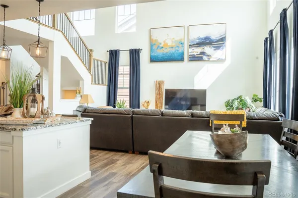 a living room with stainless steel appliances kitchen island granite countertop furniture and a fireplace
