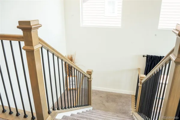 a view of staircase with railing and white walls