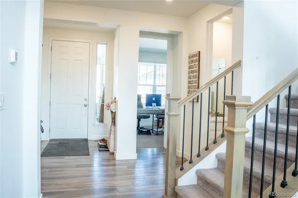 a view of an entryway with wooden floor and a livingroom