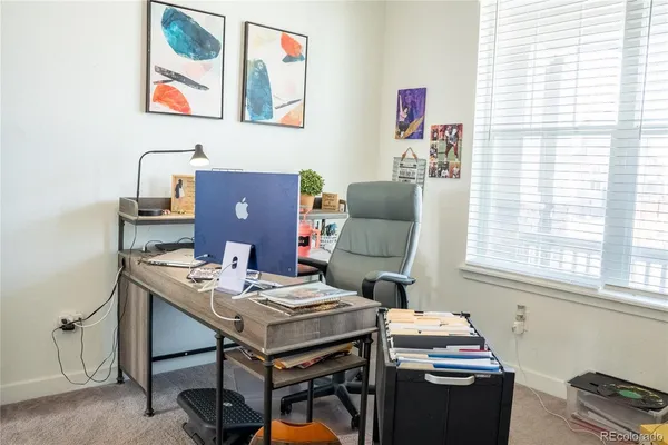 a view of a workspace with furniture and a window
