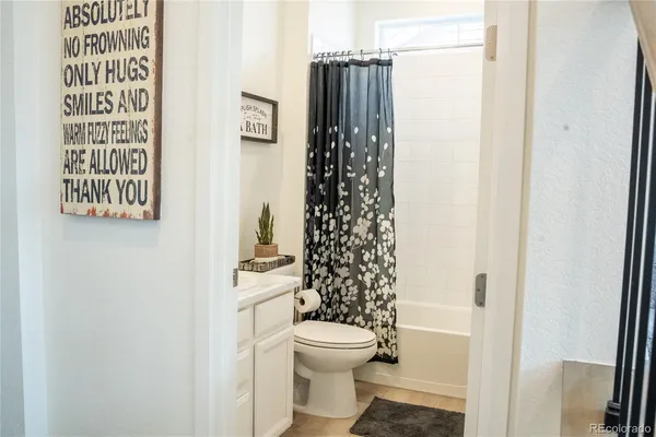 a bathroom with a toilet and a shower curtain