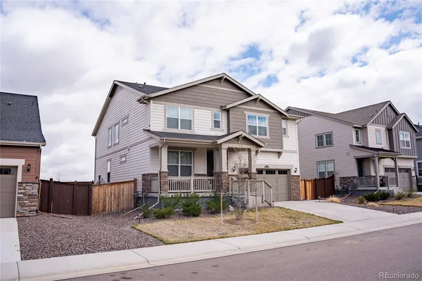 a front view of a house with garden and plants