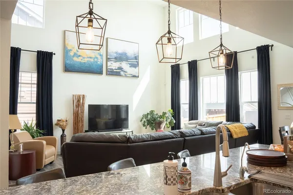 a living room with furniture a fireplace and a chandelier