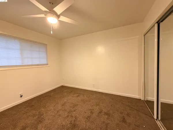 an empty room with a chandelier fan