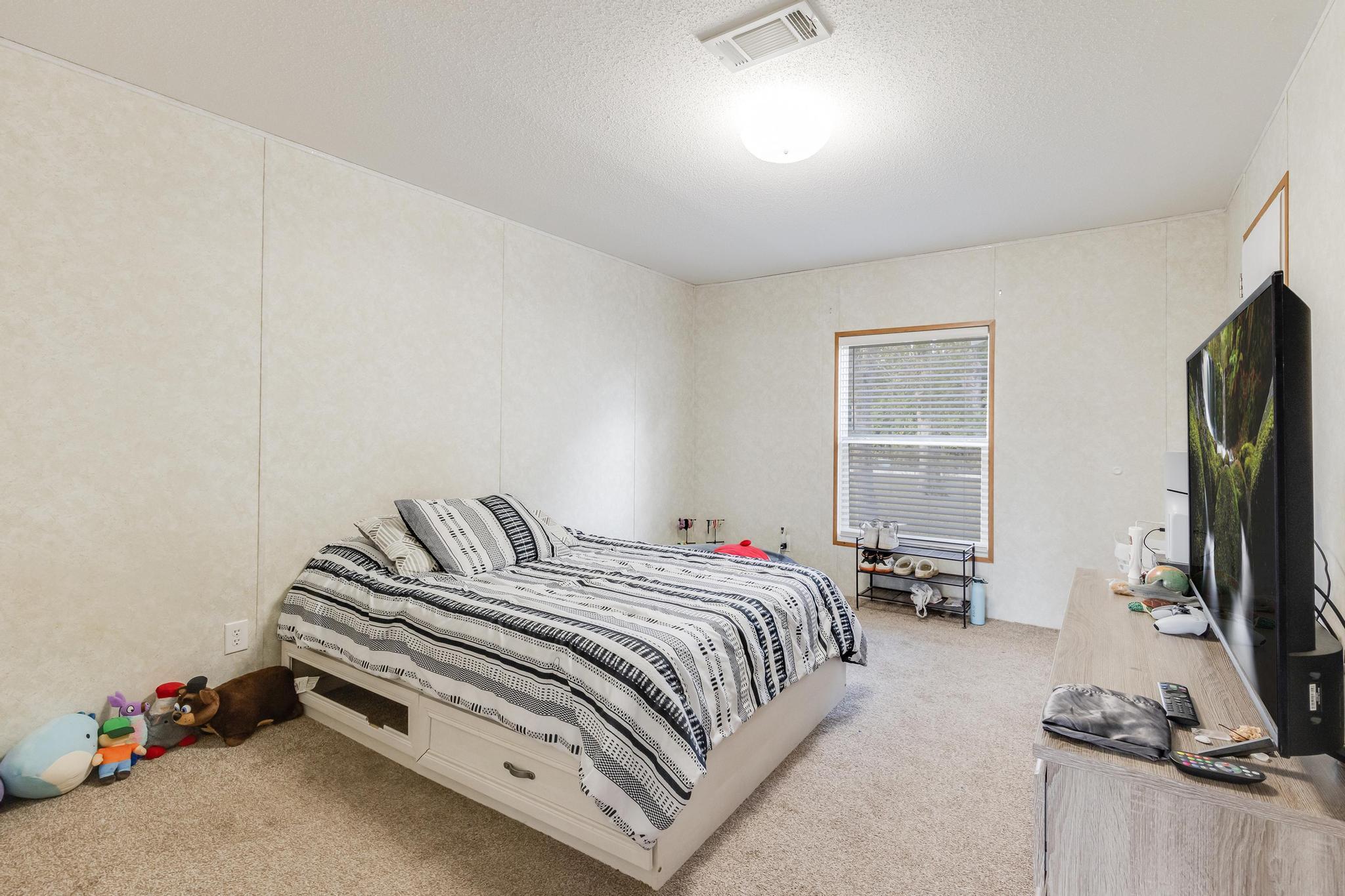 960 State Line Road DeFuniak Springs, FL 32433 - Photo 29 of 51 a bedroom with a bed and a flat tv screen on a dresser