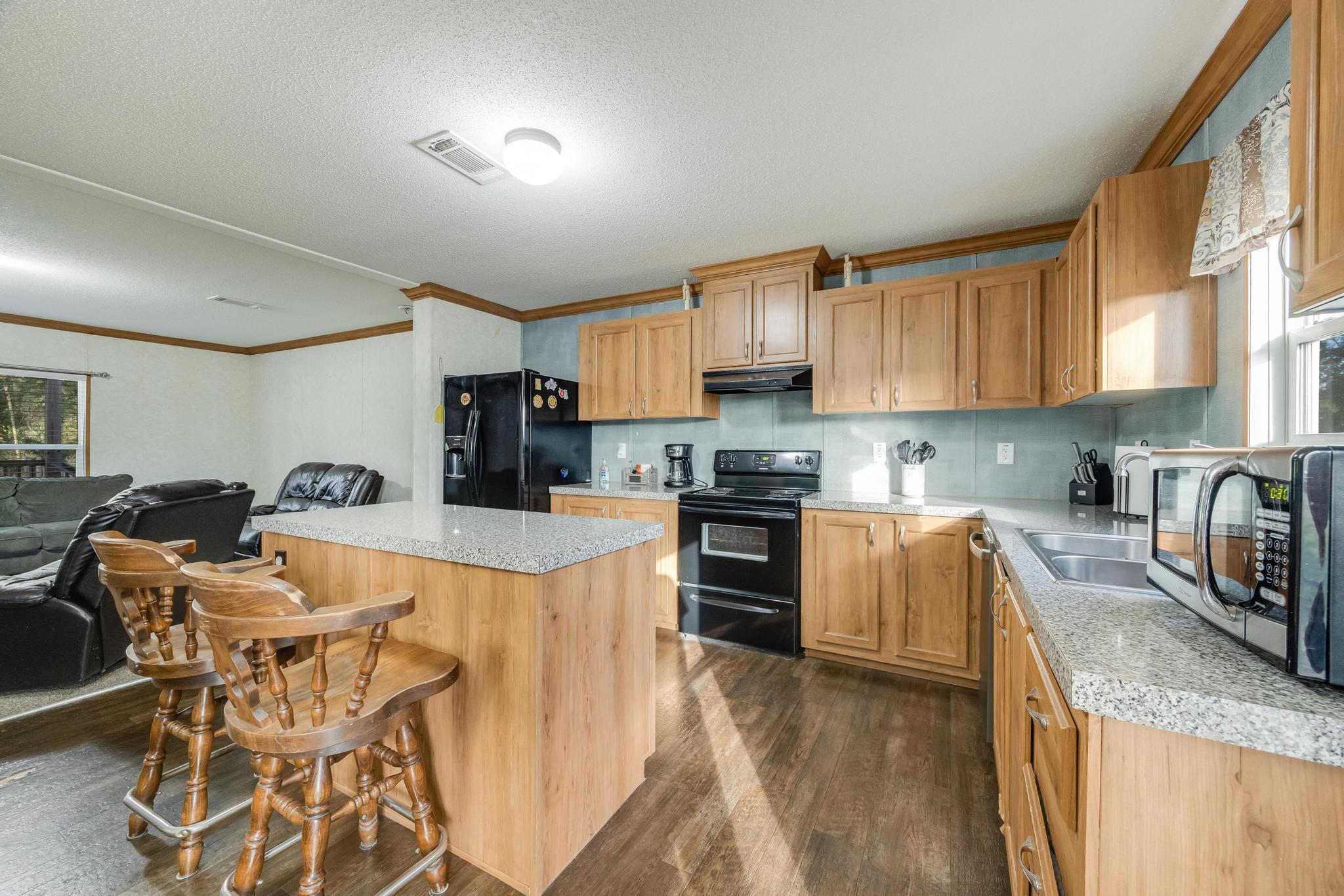 960 State Line Road DeFuniak Springs, FL 32433 - Photo 8 of 51 a kitchen with stainless steel appliances granite countertop a refrigerator stove microwave and sink