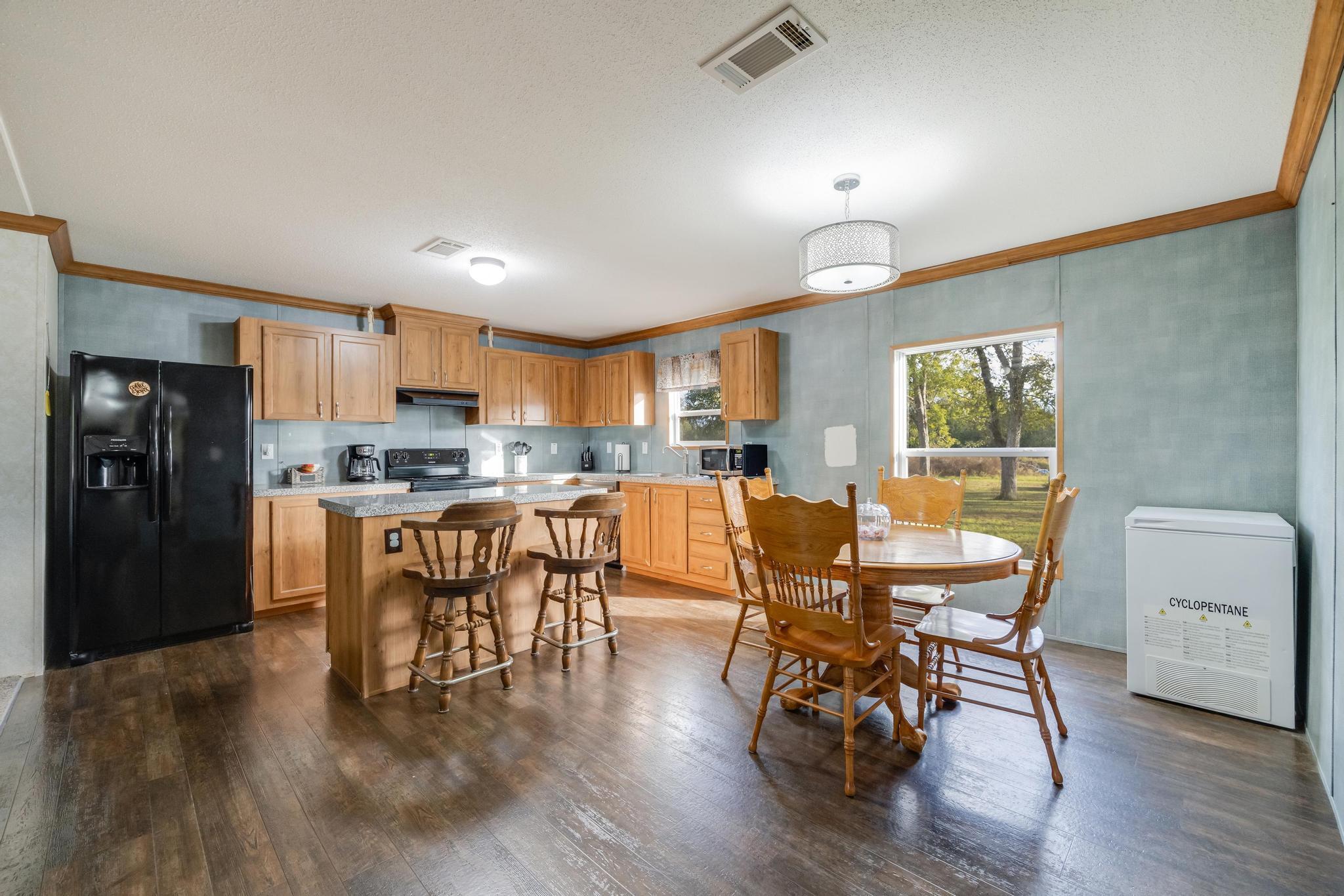 960 State Line Road DeFuniak Springs, FL 32433 - Photo 9 of 51 a kitchen with stainless steel appliances wooden floors and dining table